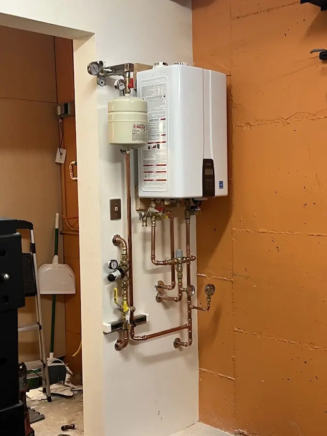 Plumbing technician inspecting water heater connections in Middlesborough